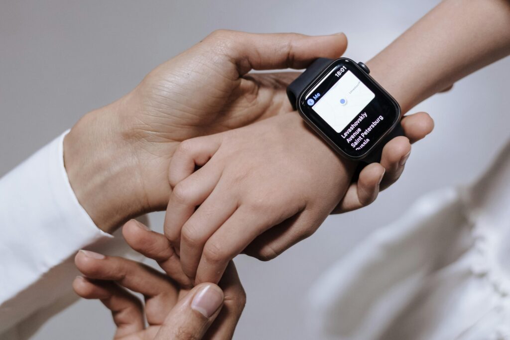 Close-up of a mother assisting her daughter with a smartwatch, emphasizing family care and technology.