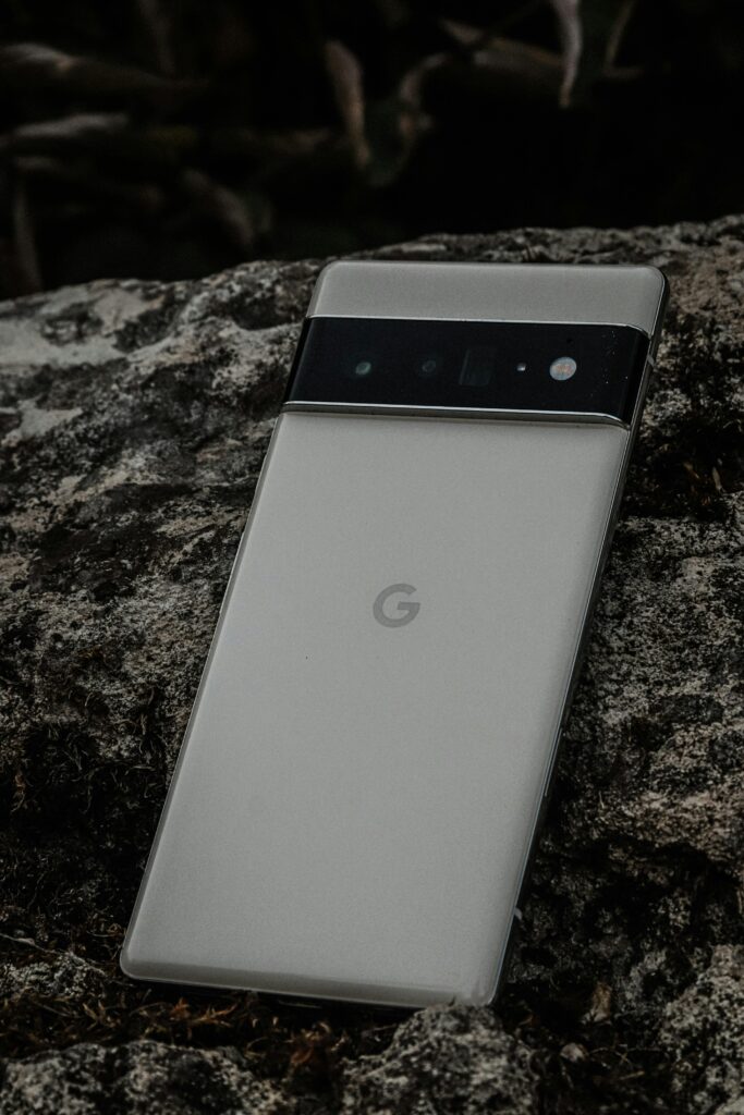 Close-up of a sleek camera phone on textured stone, showcasing modern design.